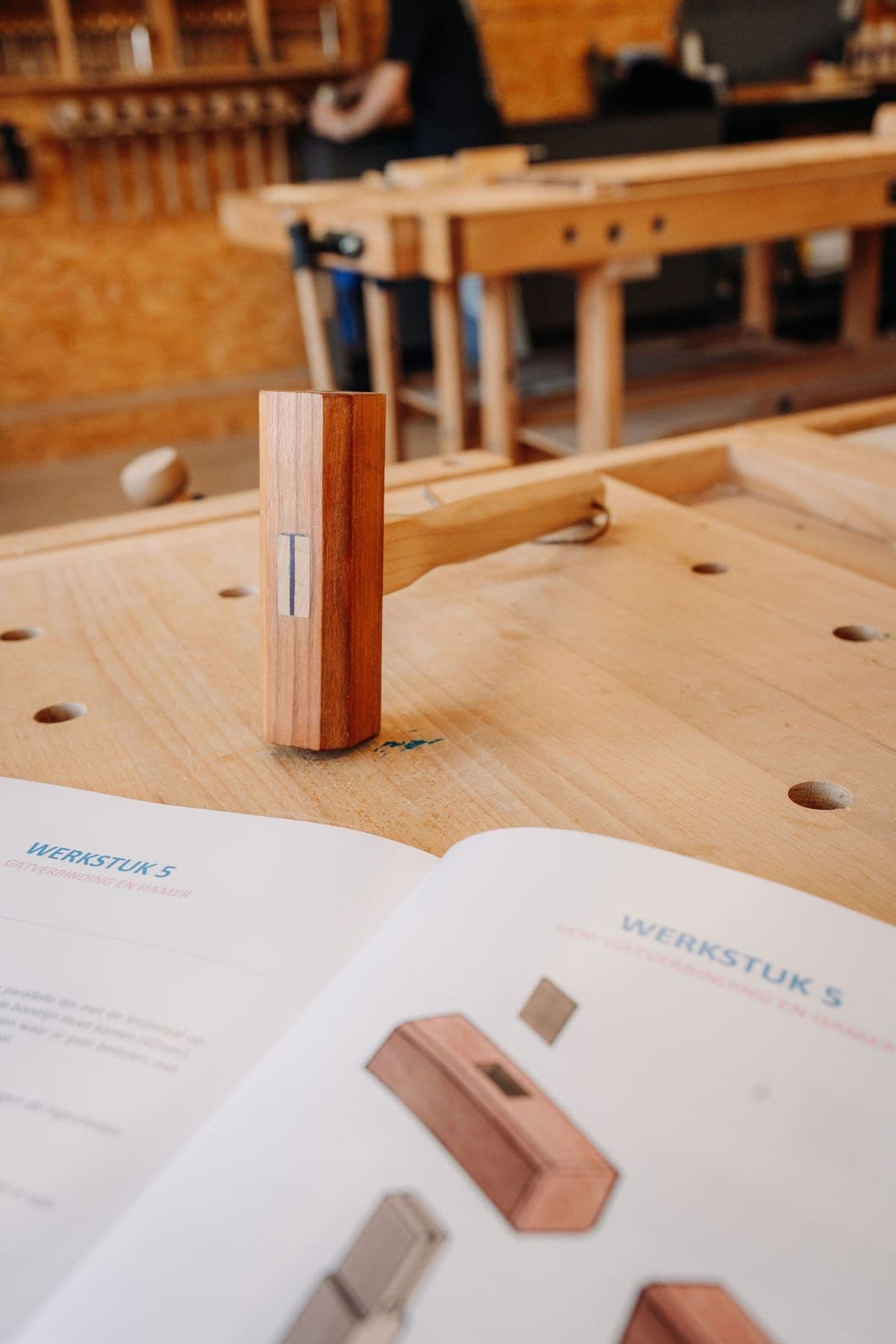 Course booklet and a hand-made mallet on a workbench
